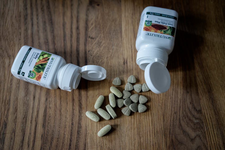 Top view of set of various medical pills arranged near plastic containers on wooden table