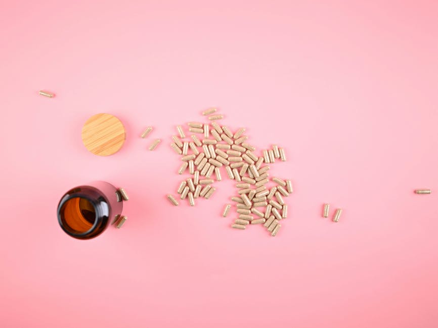 Brown bottle with scattered herbal supplement capsules on a pastel pink background.